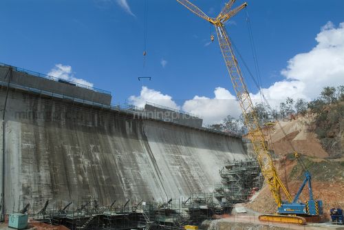 Large tower travel crane set up at dam site upgrade. very large wide shot showing industrial scaffolding. - Mining Photo Stock Library