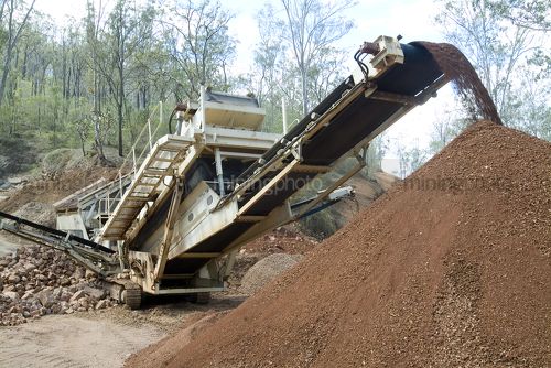 Crusher at quarry crushing rocks into road base. - Mining Photo Stock Library