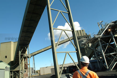 Worker in ppe walking through coal wash plant. - Mining Photo Stock Library