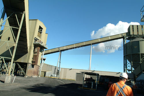 Worker in full ppe walking through a coal wash plant. - Mining Photo Stock Library