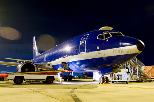 747 plane on tarmac being loaded at night time. - Mining Photo Stock Library