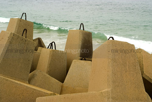 Large concrete blocks as ocean retaining wall to stop beach erosion. - Mining Photo Stock Library