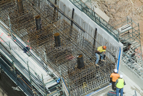 Workers in teamwork preparing concrete steel formwork.  bridge or dam work. aerial shot. - Mining Photo Stock Library