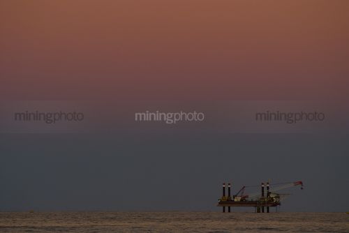 Offshore desalination plant drill rig working close to shore. shot at sunset, good colours. - Mining Photo Stock Library