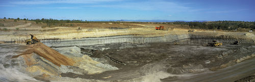Wide panorama shot of open cut coal mine.  haul trucks dumping, excavator loading.  - Mining Photo Stock Library