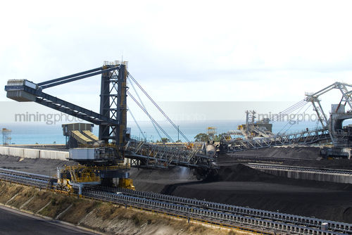Close up of coal reclaimer working at shipping terminal.   - Mining Photo Stock Library