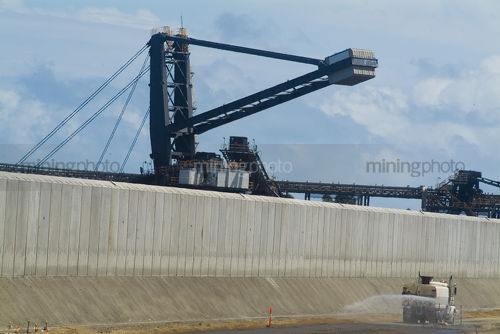 Close up water cart spraying for dust suppresion inside coal terminal. - Mining Photo Stock Library