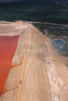 Mine truck driving atop tailings dam wall. aerial photo - Mining Photo Stock Library