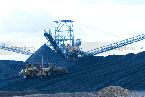 Two bulldozers pushing coal onto stockpile at coal wash plant hopper and rail terminal. - Mining Photo Stock Library