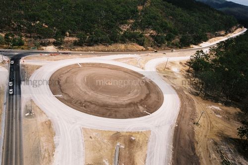 Cars detouring around the constructing of a roundabout on a highway - Mining Photo Stock Library