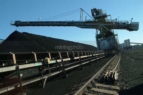 Coal loader stockpiling coal at rail terminal. - Mining Photo Stock Library