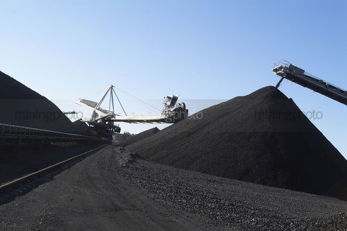 Reclaimer and loader amongst coal stockpiles - Mining Photo Stock Library