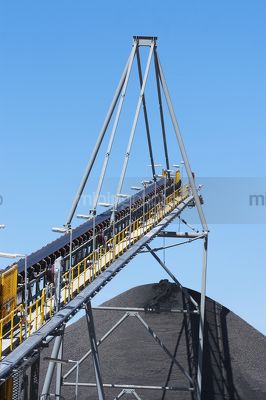 High coal conveyor loading to a coal stockpile.  vertical image. - Mining Photo Stock Library