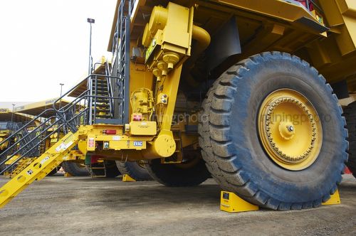 Close up of haul truck on go line with a wheel chock. - Mining Photo Stock Library