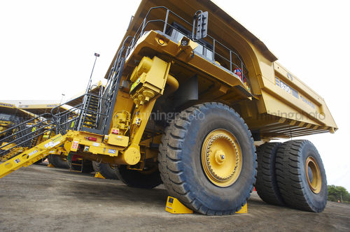 Wide shot of wheel chock in place on haul truck in go line. - Mining Photo Stock Library