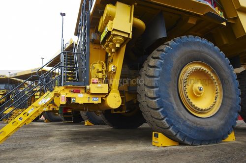 Close up photo of haul trucks at go line stopped by wheel chocks - Mining Photo Stock Library