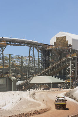 Vertical shot of multi level  gold processing plant with conveyors and light vehicle moving in foreground.  great production photo. - Mining Photo Stock Library