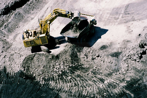 Aerial of excavator loading truck - Mining Photo Stock Library
