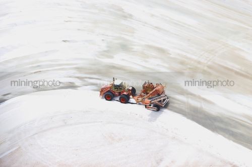 Tractor loader at salt lakes waiting to load salt into trucks. - Mining Photo Stock Library