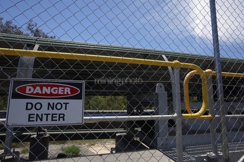 Covered coal conveyor behind wire fence with do not enter sign posted. - Mining Photo Stock Library