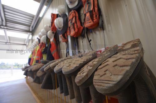 Gumboots, hard hats and safrty bags hanging in lunch room area. - Mining Photo Stock Library