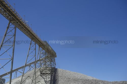 Conveyor  up to stockpile with blue sky behind. - Mining Photo Stock Library