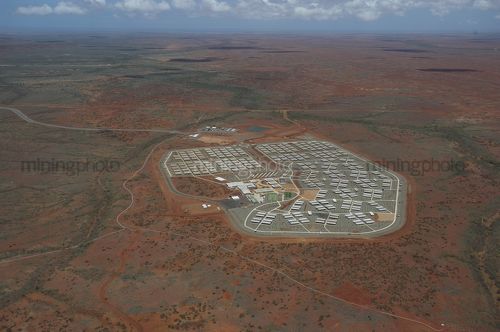 High aerial shot of 3000 person mine camp.  there is wilderness in background way back to horizon.  - Mining Photo Stock Library