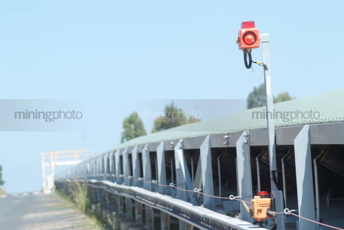Covered coal conveyor overland. clearly showing safety pull switch - Mining Photo Stock Library
