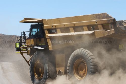 Empty 785c haul truck moving on haul road in open cut mine.  close up photo - Mining Photo Stock Library