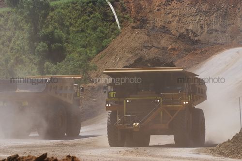 Two haul trucks pass on a haul road in an open cut coal mine. - Mining Photo Stock Library