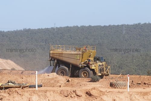 Water cart in open cut mine spraying for dust suppression. - Mining Photo Stock Library