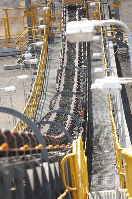Conveyor loaded with coal in open cut coal mine.  close up vertical shot. - Mining Photo Stock Library