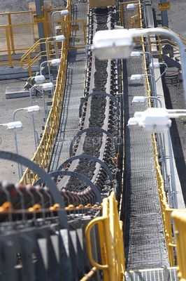 Close up vertical shot of coal conveyor moving at wash plant in open cut coal mine. - Mining Photo Stock Library
