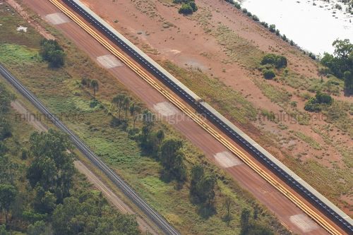 Aerial photo of covered overland conveyor with access road and rail line adjacent. - Mining Photo Stock Library