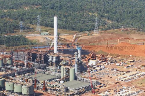 Aerial shot of bauxite alumina refinery.  bauxite stockpiles in background.  giant processing plant. - Mining Photo Stock Library