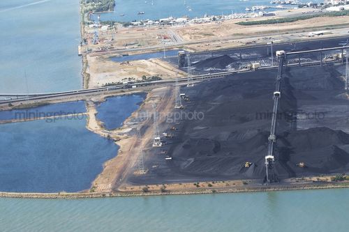 Aerial photo of stockpiled coal at coal terminal. Bulldozer 's working around stockpiles. - Mining Photo Stock Library