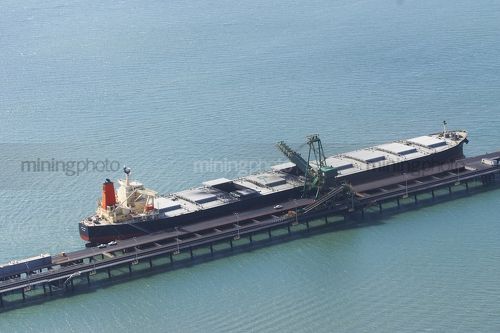 Aerial photo of coal ship being loaded at terminal.  conveyor moving. - Mining Photo Stock Library