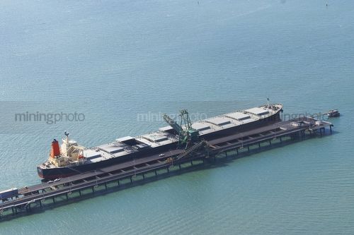 Aerial photo of a coal loader at shipping wharf loading a ship. - Mining Photo Stock Library