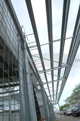 Steel framework of building in construction adjacent to public road - Mining Photo Stock Library
