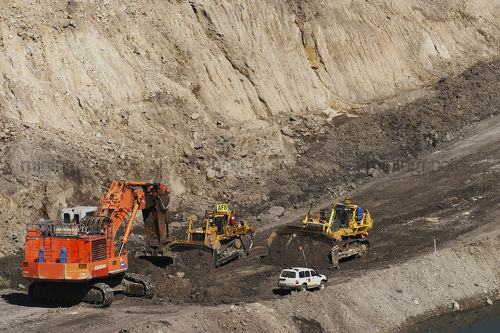 EX2500 excavator with 2 two dozers and light vehicle in open cut coal mine.  haul access road and mine water storage in shot. - Mining Photo Stock Library