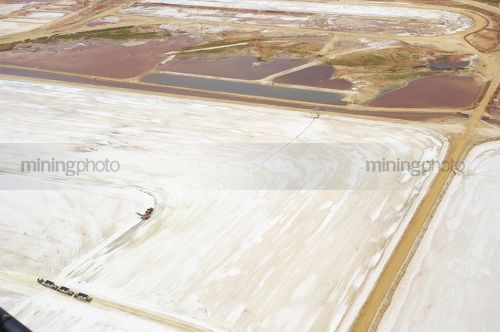 Aerial photo of multi trailer haul truck being loaded in salt plains. wide shot. - Mining Photo Stock Library