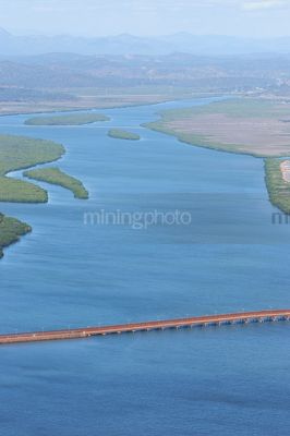 Vertical aerial photo of bauxite conveyor over waterway.  mangrove, blue waterways in background. - Mining Photo Stock Library