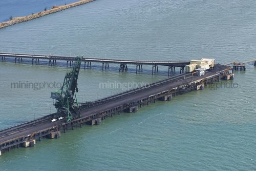 Aerial photo of light vehicles and workers on wharf at coal terminal.  wharf is out to sea. - Mining Photo Stock Library