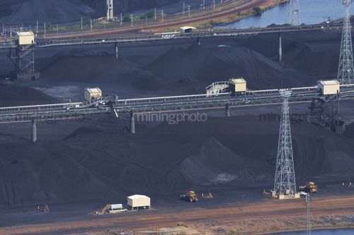Close up aerial photo of stockpiled coal awaiting ship loading at terminal.  lots of overhead and land conveyors. - Mining Photo Stock Library