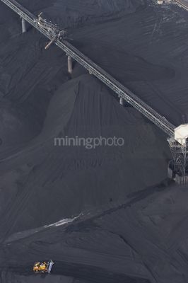 Vertical aerial photo of dozer stockpiling coal into hopper at coal terminal.  overhead conveyors.  coal to all edges of photo. - Mining Photo Stock Library