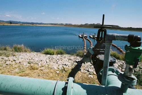 Water pump adjacent to a  very large dam in open cut coal mine. - Mining Photo Stock Library