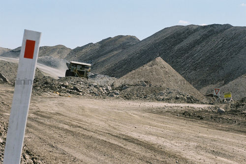 Haul truck on haul road in open cut mine.  shot at road level.  great shot for double page spread with room for copy on right side. - Mining Photo Stock Library