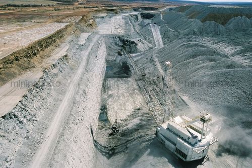 Aerial photo of dragline moving overburden in open cut coal mine. Excavator and truck rotation in background. - Mining Photo Stock Library