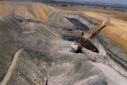Aerial photo of dragline in open cut coal mine with light vehicle adjacent for scale.  Excavator moving coal.  Great shot of coal seam in high wall. - Mining Photo Stock Library