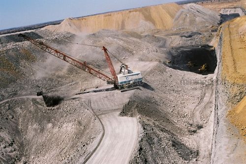 Aerial photo of dragline in open cut coal mine with light vehicle adjacent for scale.  Excavator moving coal and truck rotation. - Mining Photo Stock Library